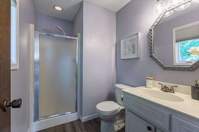 15461 Harney St, Omaha, NE 68154 - bathroom featuring vanity, a shower stall, wood finished floors, toilet, and a textured ceiling
