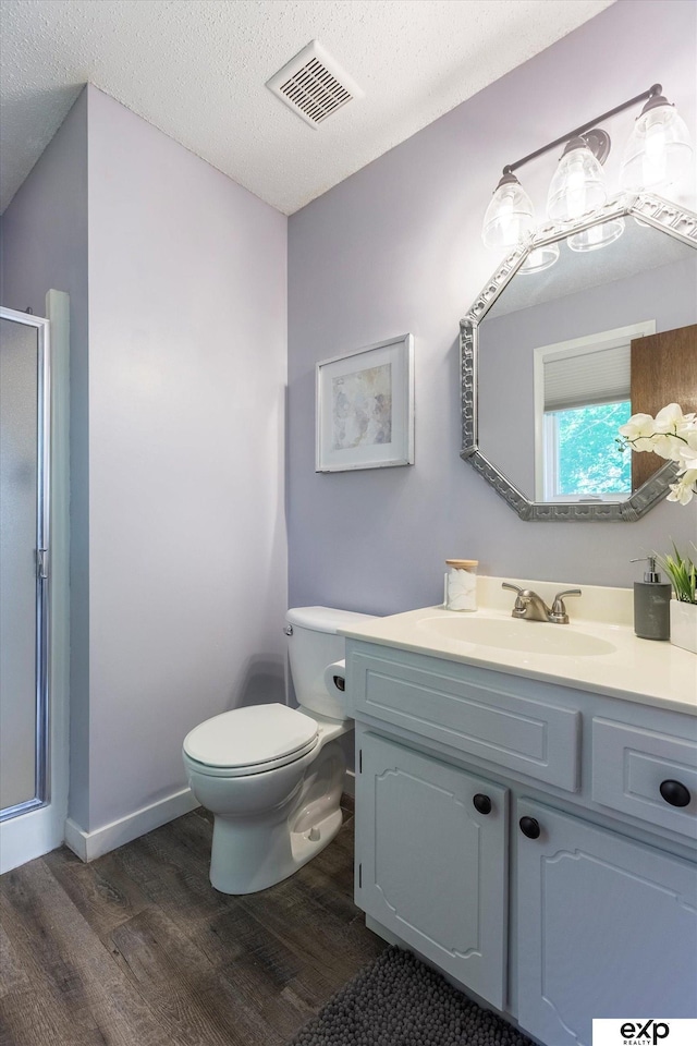 15461 Harney St, Omaha, NE 68154 - bathroom with wood finished floors, vanity, a shower stall, toilet, and a textured ceiling
