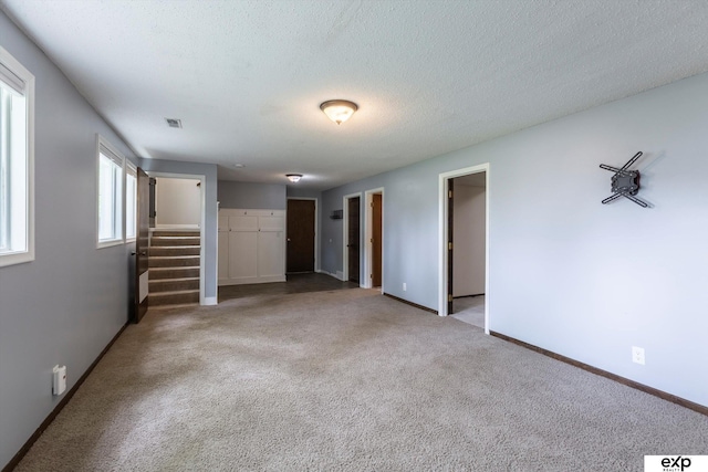 15461 Harney St, Omaha, NE 68154 - unfurnished living room featuring stairs, carpet, baseboards, and a textured ceiling