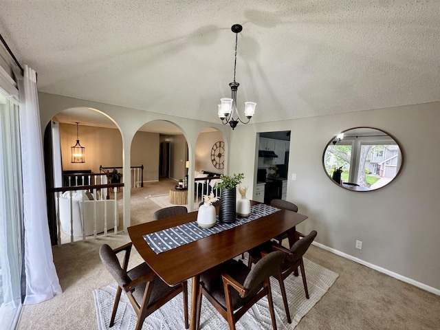 15461 Harney St, Omaha, NE 68154 - dining area with arched walkways, a chandelier, a textured ceiling, light colored carpet, and vaulted ceiling