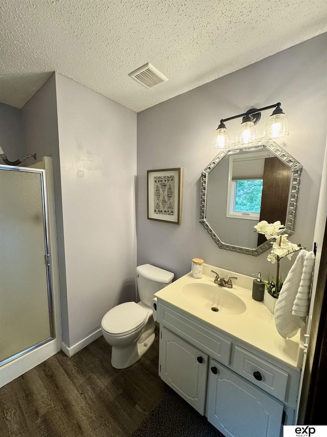 15461 Harney St, Omaha, NE 68154 - bathroom featuring wood finished floors, a shower stall, vanity, toilet, and a textured ceiling