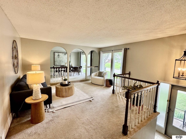 15461 Harney St, Omaha, NE 68154 - living room with carpet, a textured ceiling, and a chandelier