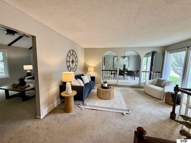 15461 Harney St, Omaha, NE 68154 - carpeted living room with arched walkways, a textured ceiling, and baseboards