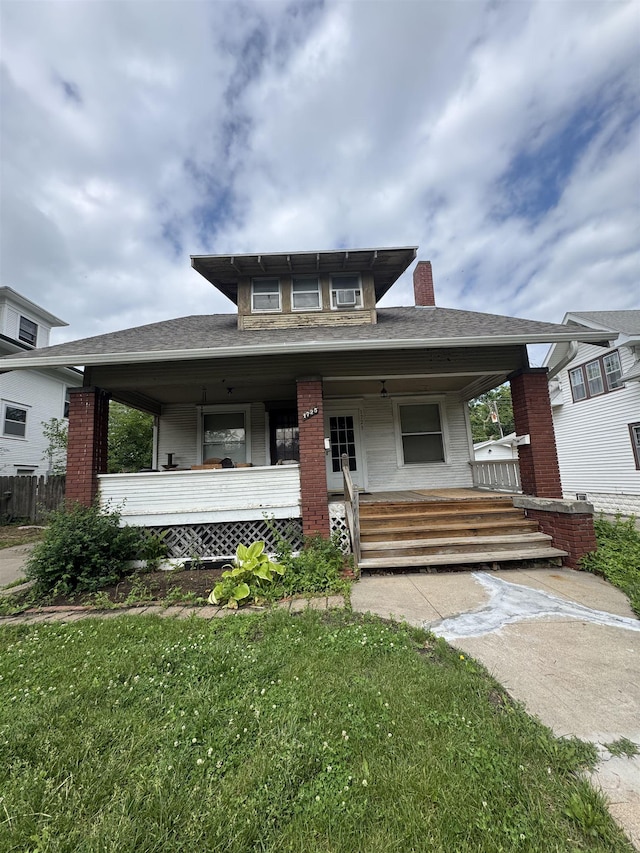 1725 S 23rd St, Lincoln, NE 68502 - view of front of house featuring a porch, a front yard, a chimney, and brick siding