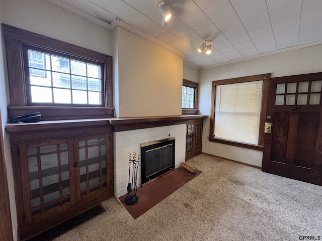 1725 S 23rd St, Lincoln, NE 68502 - unfurnished living room featuring crown molding, carpet flooring, a fireplace, and baseboards