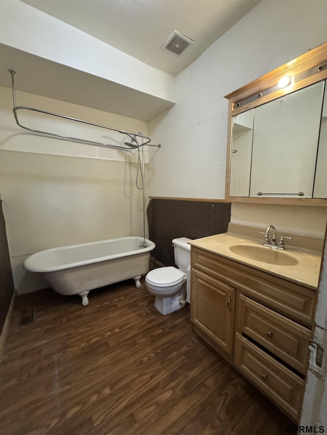 1725 S 23rd St, Lincoln, NE 68502 - bathroom featuring a freestanding bath, wood finished floors, vanity, and toilet