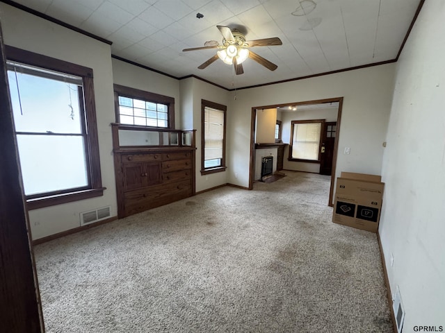 1725 S 23rd St, Lincoln, NE 68502 - unfurnished living room with carpet flooring, ceiling fan, crown molding, a fireplace with flush hearth, and baseboards