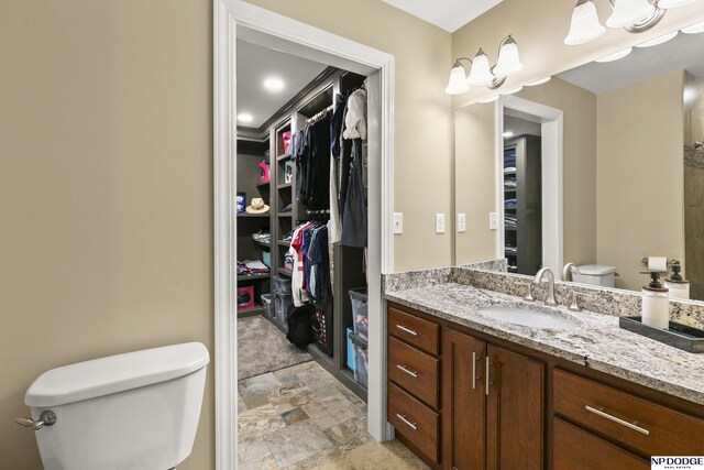 S-1020 Platte Shore Dr, Fremont, NE 68025 - full bath featuring toilet, vanity, a walk in closet, and stone finish floors