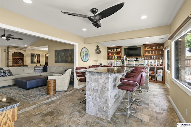 S-1020 Platte Shore Dr, Fremont, NE 68025 - indoor bar featuring a ceiling fan, stone tile flooring, baseboards, and recessed lighting