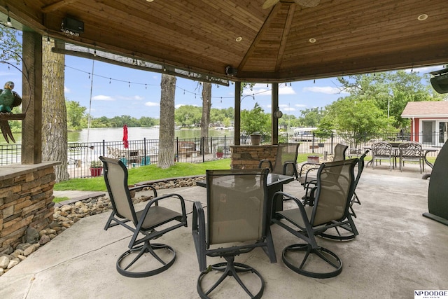S-1020 Platte Shore Dr, Fremont, NE 68025 - fenced backyard with outdoor dining area, a patio area, and a water view