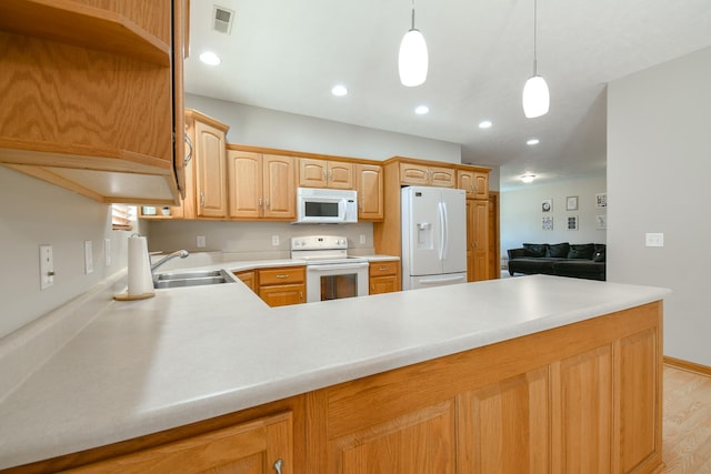 3934 Ballard Ct, Lincoln, NE 68504 - kitchen with white appliances, a sink, a peninsula, light countertops, and decorative light fixtures