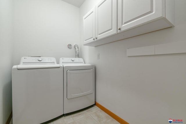 3934 Ballard Ct, Lincoln, NE 68504 - laundry area with cabinet space, washer and clothes dryer, light tile patterned floors, and baseboards