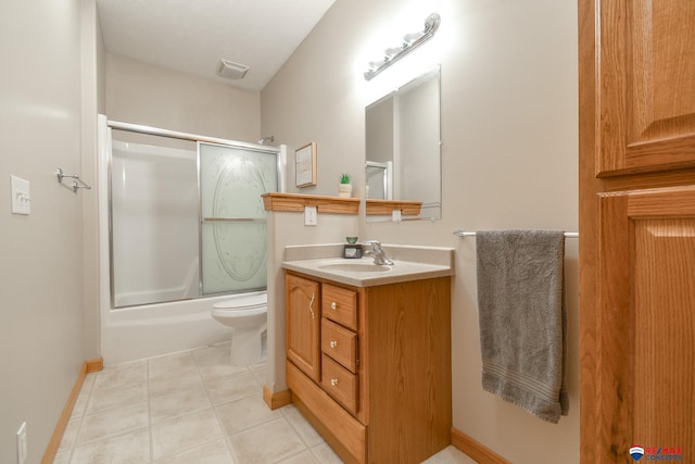 3934 Ballard Ct, Lincoln, NE 68504 - full bathroom with toilet, vanity, bath / shower combo with glass door, baseboards, and tile patterned floors