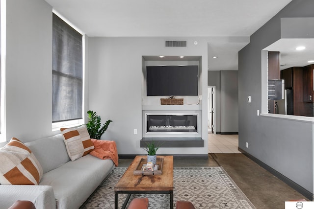 100 N 12th St Unit 904, Lincoln, NE 68508 - living area featuring baseboards, finished concrete flooring, a glass covered fireplace, and recessed lighting