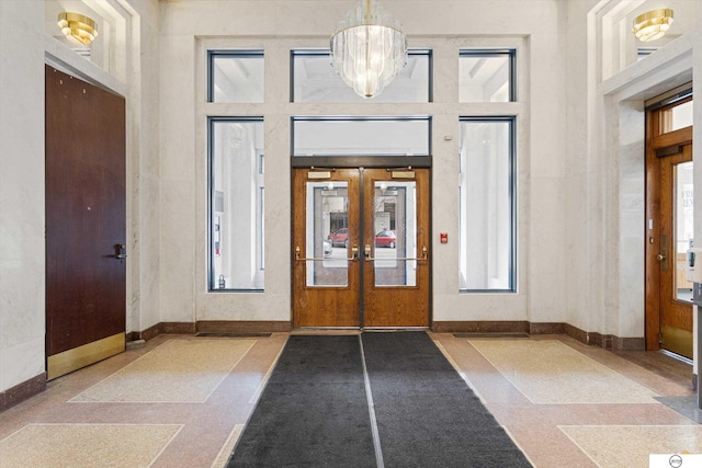 100 N 12th St Unit 904, Lincoln, NE 68508 - foyer entrance with french doors, a chandelier, baseboards, a high ceiling, and healthy amount of natural light