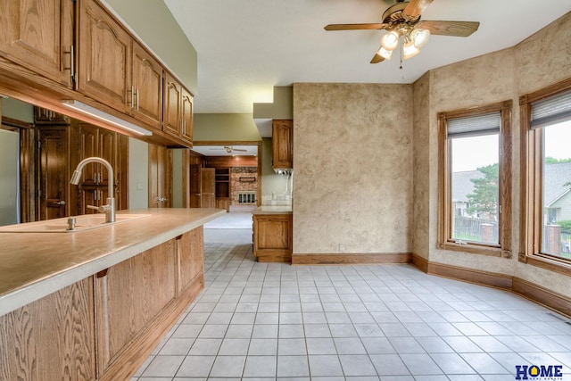 8240 Dorset Dr, Lincoln, NE 68510 - kitchen featuring a sink, brown cabinets, a ceiling fan, and light countertops
