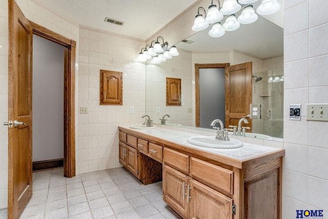 8240 Dorset Dr, Lincoln, NE 68510 - bathroom with tile walls, double vanity, a shower stall, ornamental molding, and tile patterned floors