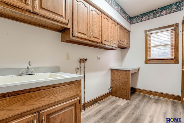 8240 Dorset Dr, Lincoln, NE 68510 - laundry area featuring cabinet space, light wood-style floors, electric dryer hookup, baseboards, and hookup for a washing machine