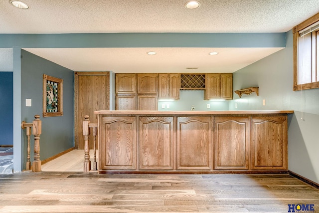 8240 Dorset Dr, Lincoln, NE 68510 - kitchen with light wood-style flooring, recessed lighting, baseboards, and a textured ceiling