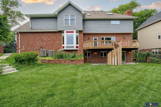 8240 Dorset Dr, Lincoln, NE 68510 - back of property featuring a wooden deck, brick siding, central AC, and a yard