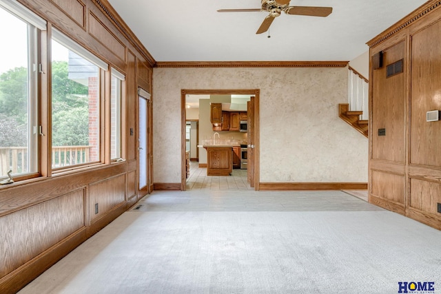 8240 Dorset Dr, Lincoln, NE 68510 - spare room featuring ceiling fan, plenty of natural light, stairway, light carpet, and crown molding