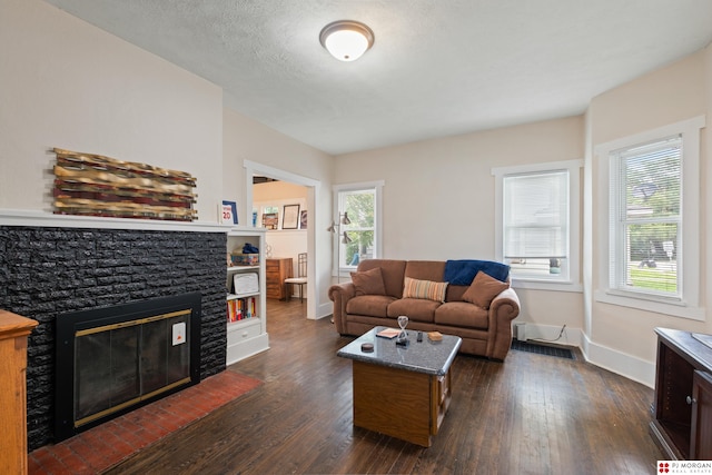 1512 N 41st Ave, Omaha, NE 68111 - living room featuring dark wood-style flooring, baseboards, and a stone fireplace
