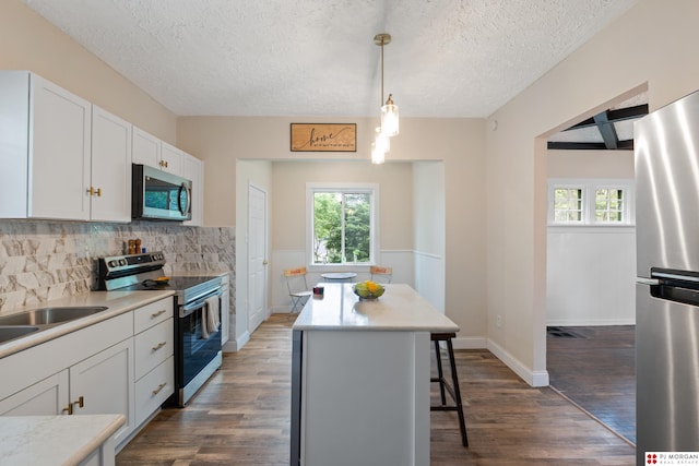 1512 N 41st Ave, Omaha, NE 68111 - kitchen with appliances with stainless steel finishes, plenty of natural light, dark wood finished floors, a textured ceiling, and a breakfast bar area