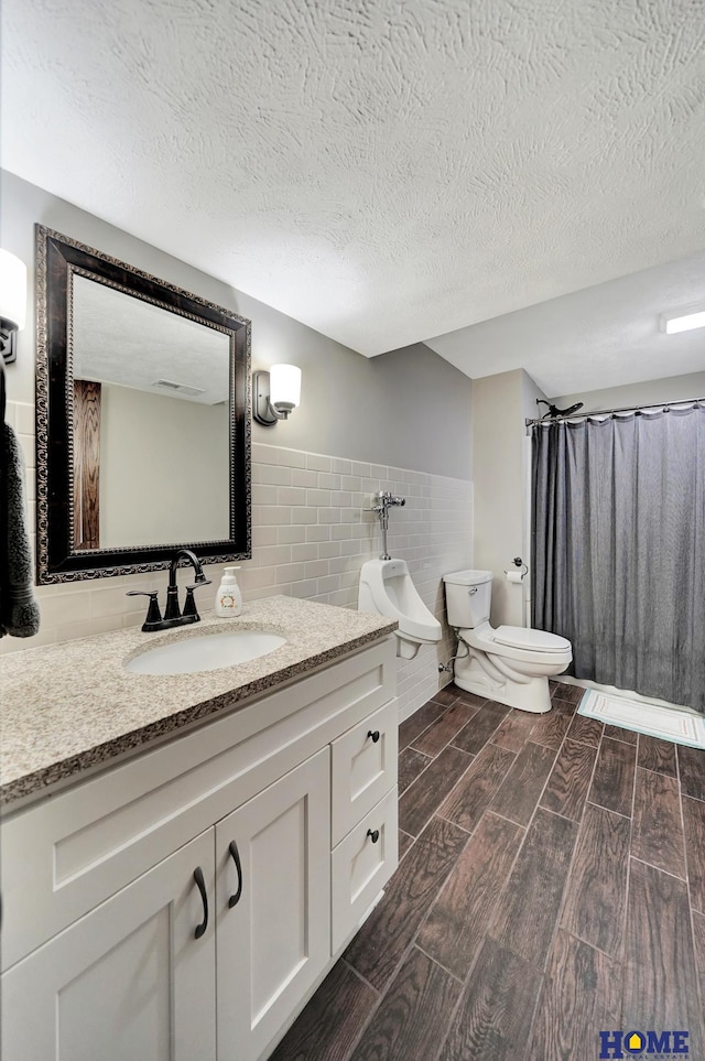1309 Ridge Rd, Hickman, NE 68372 - full bath with wood tiled floors, vanity, tile walls, a textured ceiling, and a shower with shower curtain