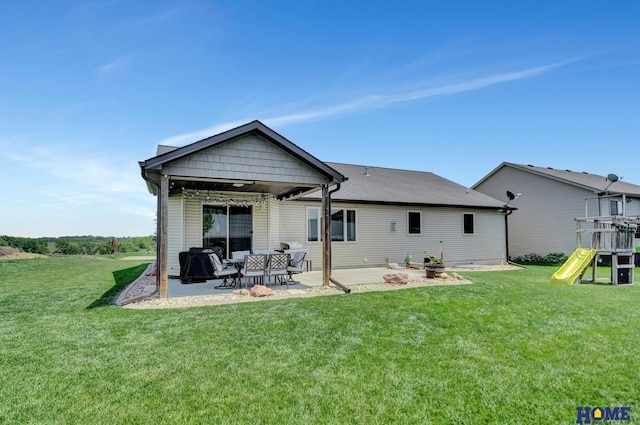 1309 Ridge Rd, Hickman, NE 68372 - rear view of house featuring a patio, a lawn, and a playground