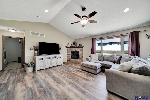 1309 Ridge Rd, Hickman, NE 68372 - living room featuring a ceiling fan, vaulted ceiling, wood finished floors, a stone fireplace, and recessed lighting