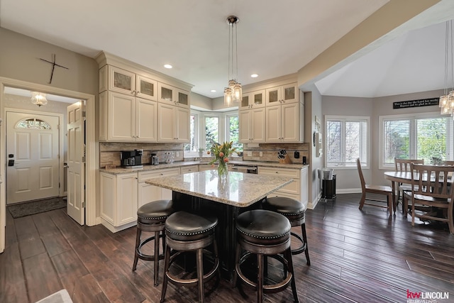 5100 Bridle Ln, Lincoln, NE 68516 - kitchen featuring glass insert cabinets, a breakfast bar, light stone countertops, backsplash, and baseboards