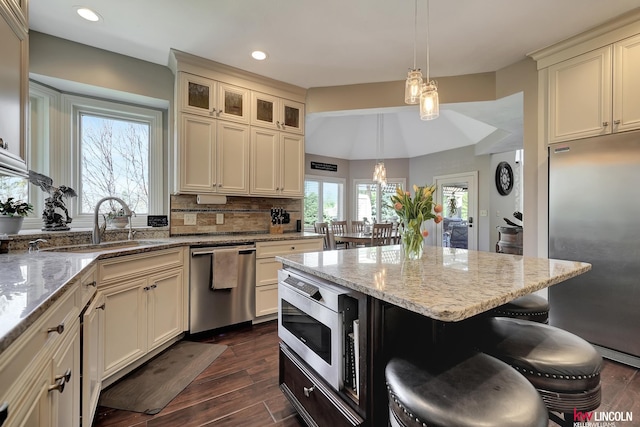 5100 Bridle Ln, Lincoln, NE 68516 - kitchen featuring stainless steel appliances, a kitchen bar, light stone countertops, recessed lighting, and dark wood-style flooring
