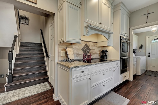 5100 Bridle Ln, Lincoln, NE 68516 - kitchen featuring separate washer and dryer, black electric stovetop, dark wood finished floors, tasteful backsplash, and stainless steel double oven