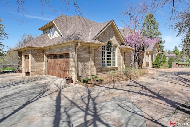 5100 Bridle Ln, Lincoln, NE 68516 - view of side of property with brick siding, driveway, an attached garage, and a shingled roof