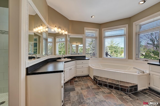 5100 Bridle Ln, Lincoln, NE 68516 - full bathroom featuring healthy amount of natural light, vanity, a garden tub, stone tile flooring, and recessed lighting