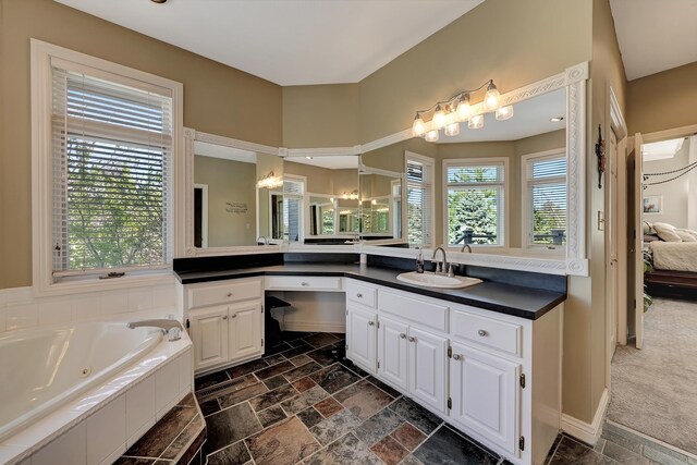 5100 Bridle Ln, Lincoln, NE 68516 - ensuite bathroom featuring stone tile floors, a whirlpool tub, and vanity