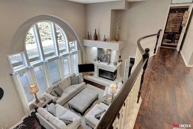 5100 Bridle Ln, Lincoln, NE 68516 - living area featuring dark wood finished floors, baseboards, a glass covered fireplace, and a towering ceiling