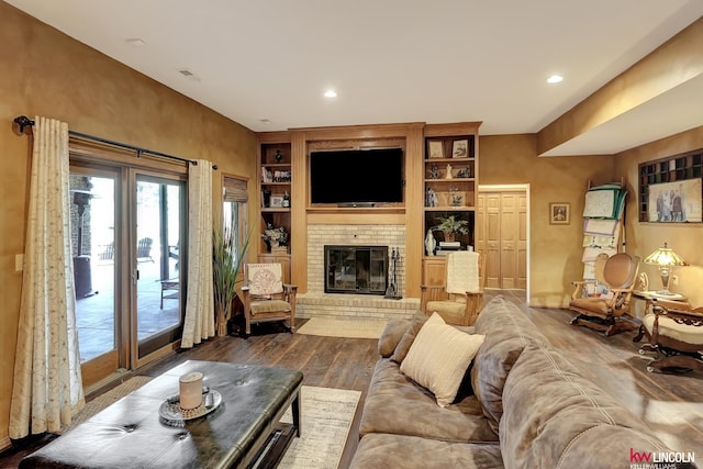 5100 Bridle Ln, Lincoln, NE 68516 - living area with dark wood finished floors, a brick fireplace, built in shelves, and recessed lighting