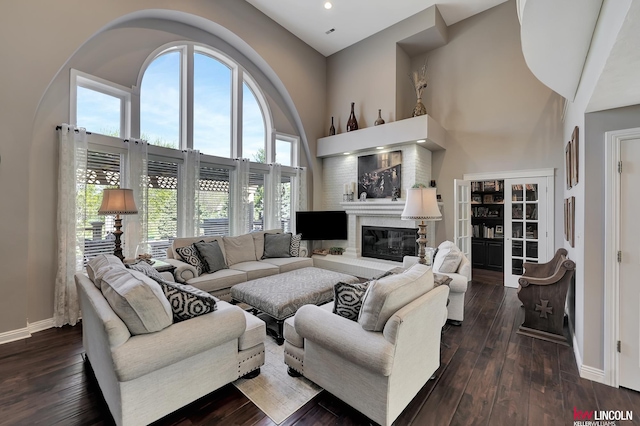 5100 Bridle Ln, Lincoln, NE 68516 - living area featuring a towering ceiling, baseboards, a glass covered fireplace, dark wood-type flooring, and recessed lighting