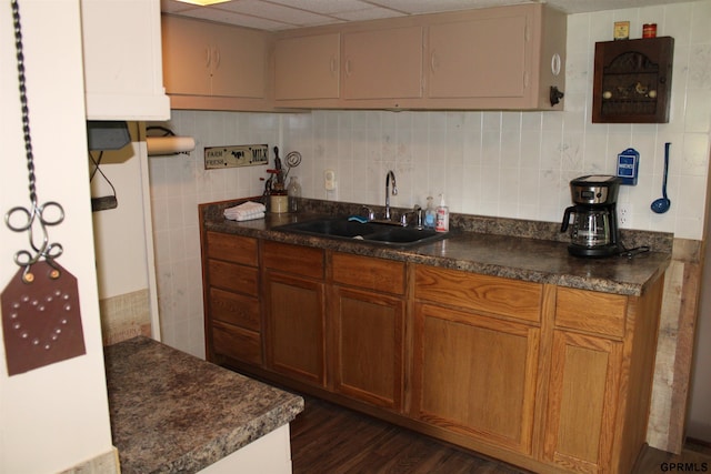 23809 F Plz Unit 9, Waterloo, NE 68069 - kitchen with a sink, dark countertops, tasteful backsplash, brown cabinetry, and dark wood-style flooring