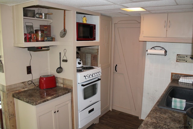 23809 F Plz Unit 9, Waterloo, NE 68069 - kitchen with white stove, dark countertops, dark wood-style floors, a sink, and white cabinets