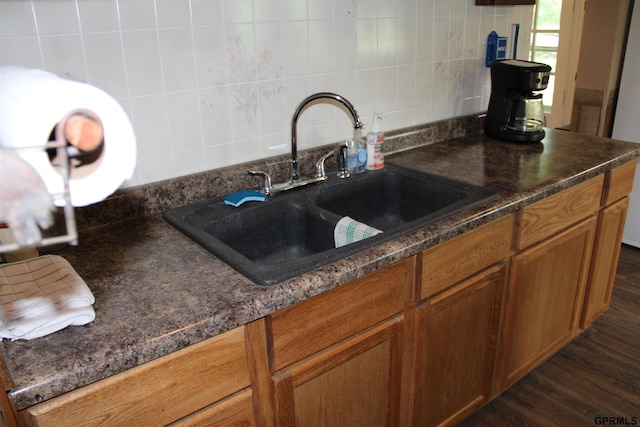 23809 F Plz Unit 9, Waterloo, NE 68069 - kitchen with a sink, dark countertops, tasteful backsplash, and brown cabinetry
