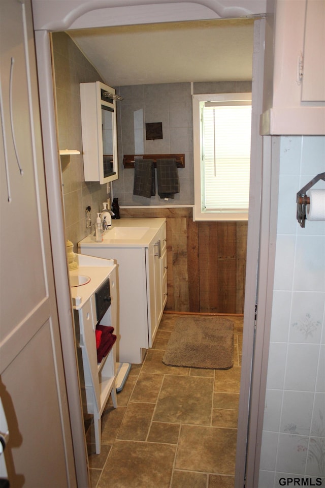 23809 F Plz Unit 9, Waterloo, NE 68069 - kitchen featuring white cabinets, tile walls, a sink, light countertops, and wood walls