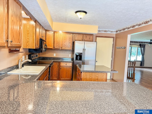 1881 Meadow Ln, Seward, NE 68434 - kitchen with black microwave, electric range oven, a sink, stainless steel fridge, and a textured ceiling