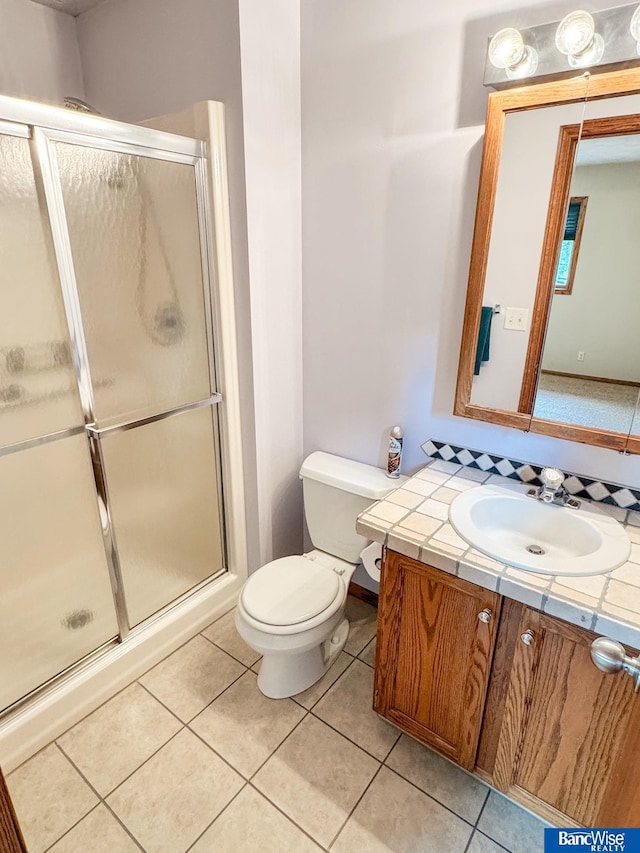1881 Meadow Ln, Seward, NE 68434 - bathroom featuring vanity, toilet, a stall shower, and tile patterned floors
