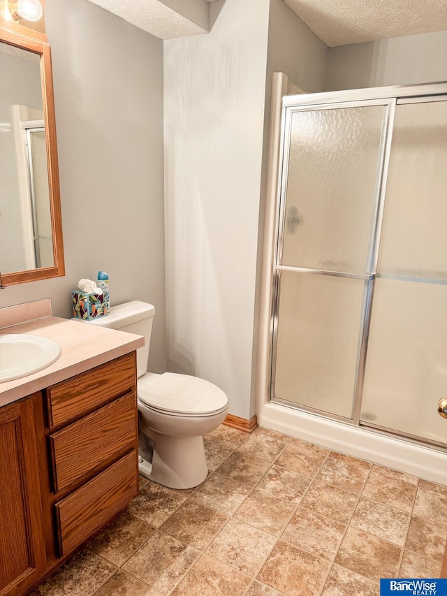 1881 Meadow Ln, Seward, NE 68434 - full bathroom with vanity, an enclosed shower, toilet, a textured ceiling, and stone finish floors