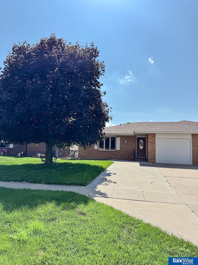 1881 Meadow Ln, Seward, NE 68434 - view of front of house with brick siding, an attached garage, a front yard, and concrete driveway