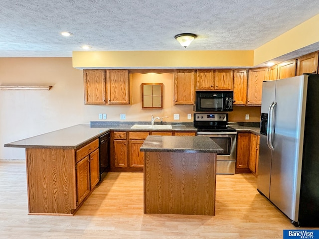 1881 Meadow Ln, Seward, NE 68434 - kitchen with black appliances, a sink, a peninsula, a textured ceiling, and dark countertops