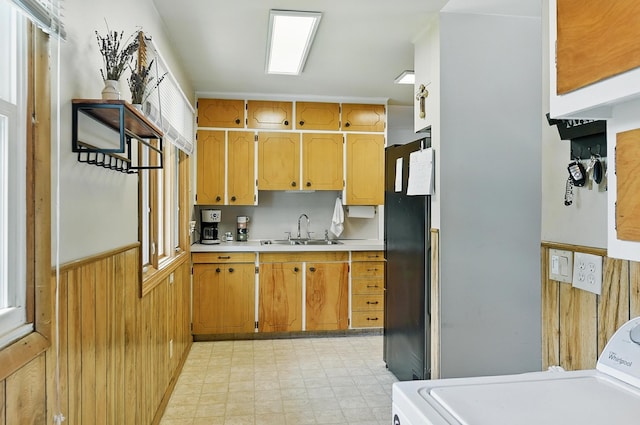 8345 Burt St, Omaha, NE 68114 - kitchen featuring washer / clothes dryer, light countertops, light flooring, freestanding refrigerator, and wood walls