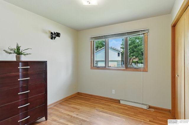 8345 Burt St, Omaha, NE 68114 - unfurnished bedroom with a baseboard radiator and light wood-style flooring